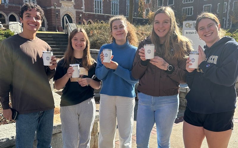 5 students holding coffee tumblers